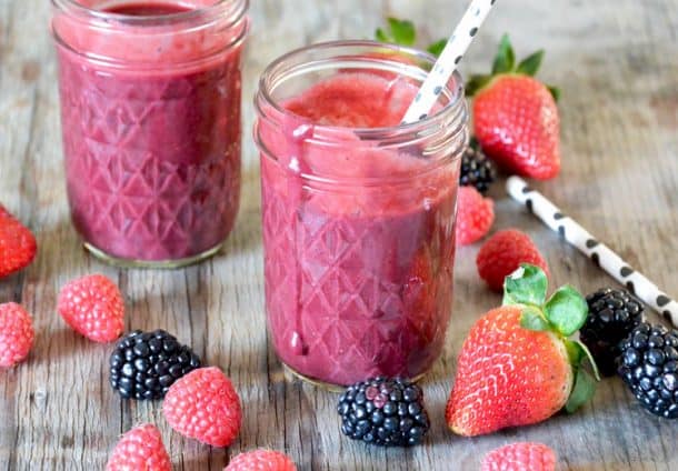 berry beet smoothie in mason jars with fresh berries all around