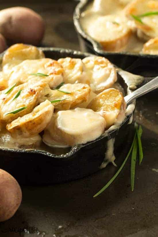 close up image of individual skillet with spoon scooping scalloped potatoes