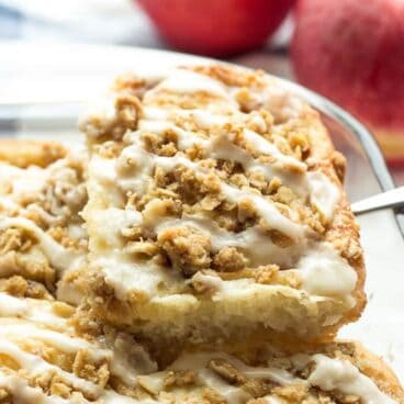 From scratch cinnamon buns stuffed with apples, topped with crunchy brown sugar streusel and topped with maple glaze -- the ultimate cinnamon roll for fall!