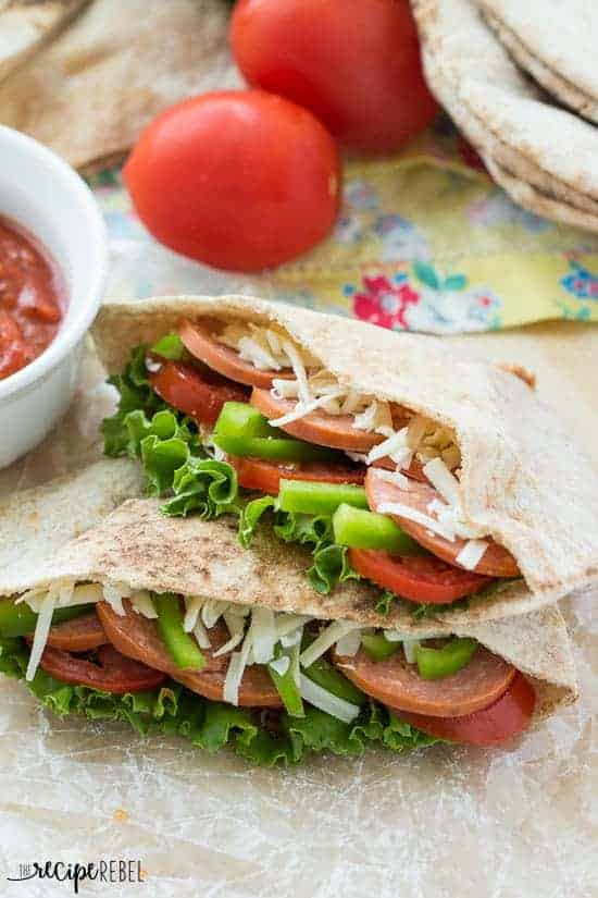 two halves of a pita stuffed with pizza fillings on a piece of parchment paper