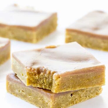 Pumpkin Spice Latte Blondies: Perfectly dense, rich pumpkin blondies covered in a coffee and spice brown sugar glaze -- the perfect fall bar! Great for your Pumpkin Spice Latte cravings or a Thanksgiving dessert! www.thereciperebel.com