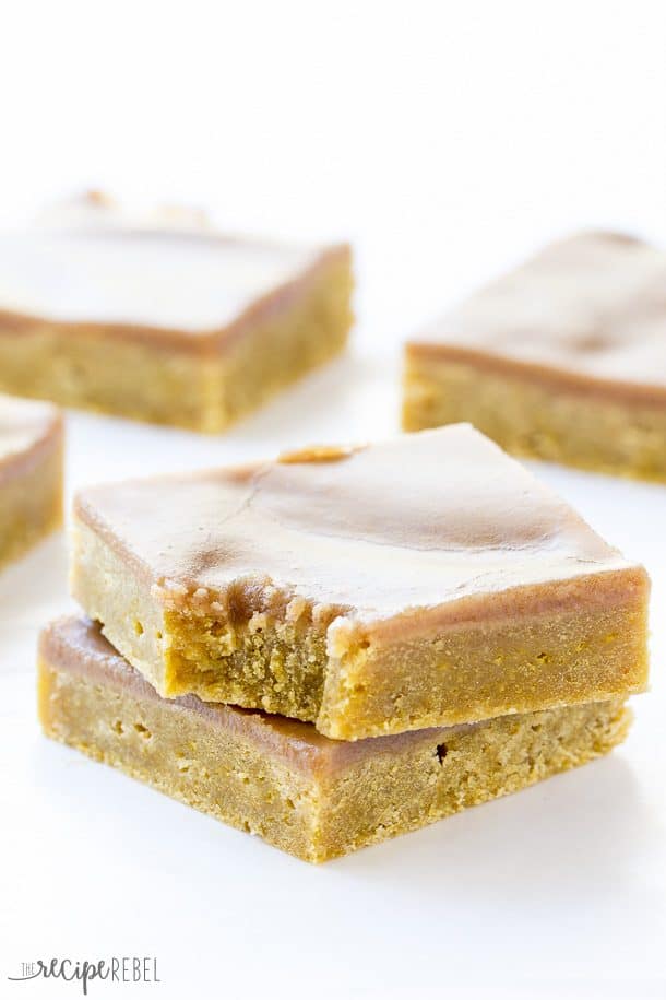 two pumpkin spice blondies stacked with a bite taken out of the top one