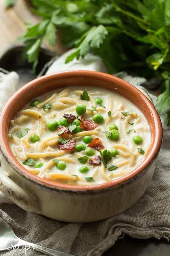 rustic bowl filled with turkey tetrazzini soup with peas and crispy bacon