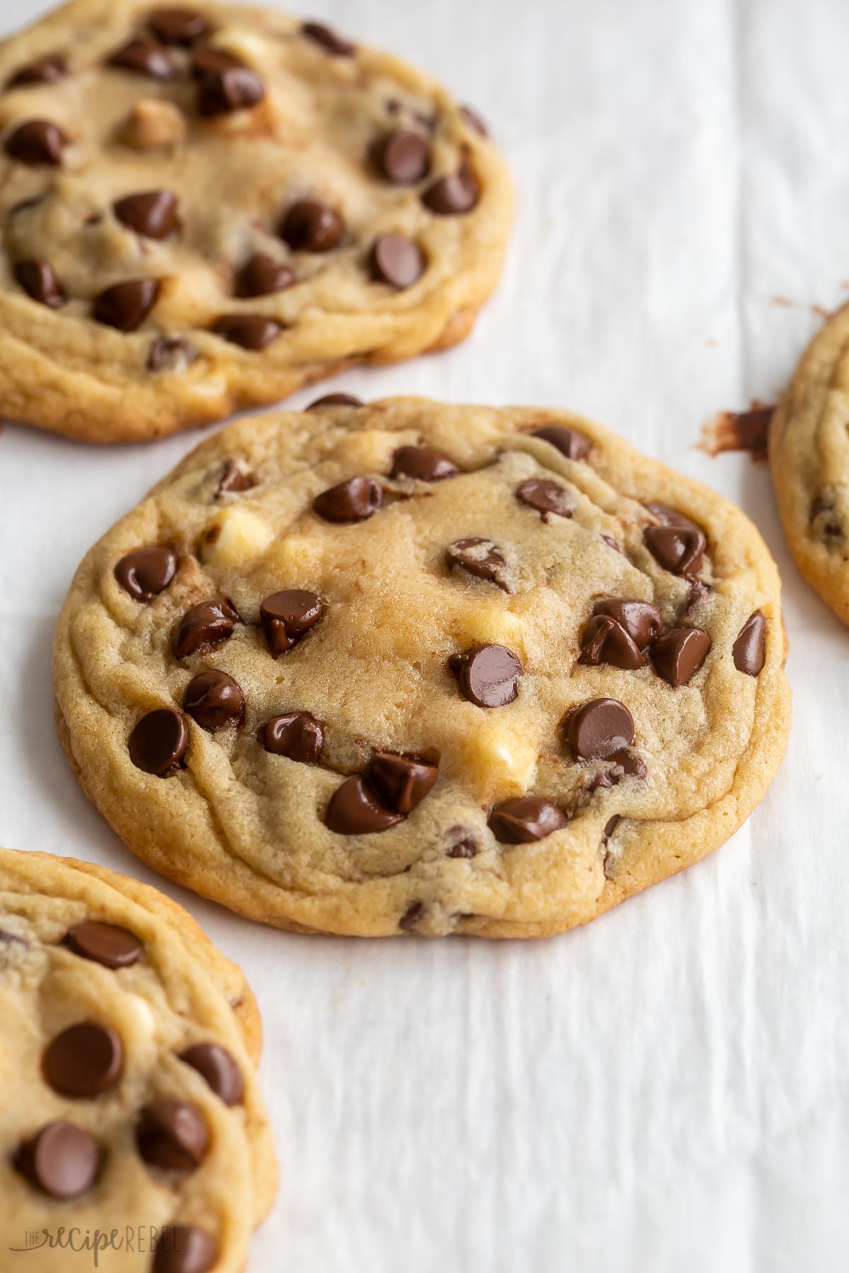 close up image of chocolate chip cookie on parchment paper