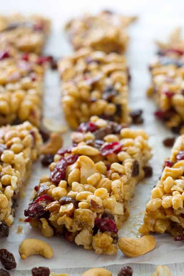 fruit and nut snack bars cut into rectangles lined up on parchment