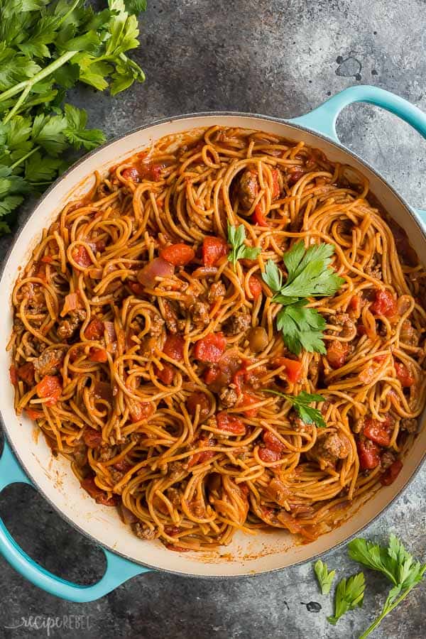 healthier one pot spaghetti and meat sauce in blue enamel pan on grey background