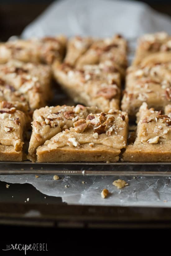 brown sugar pecan blondies cut in triangles on a sheet pan topped with chopped pecans