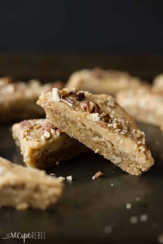 brown sugar pecan blondies cut in triangles two stacked together on black background