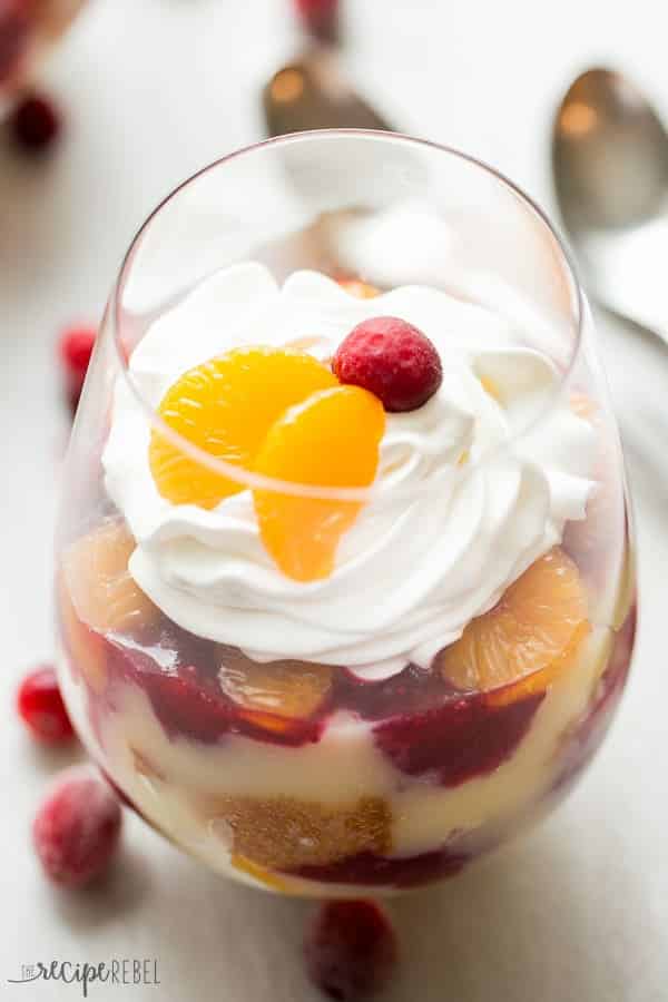 close up of stemless wine glass filled with white cake vanilla pudding mandarin oranges and cranberry sauce