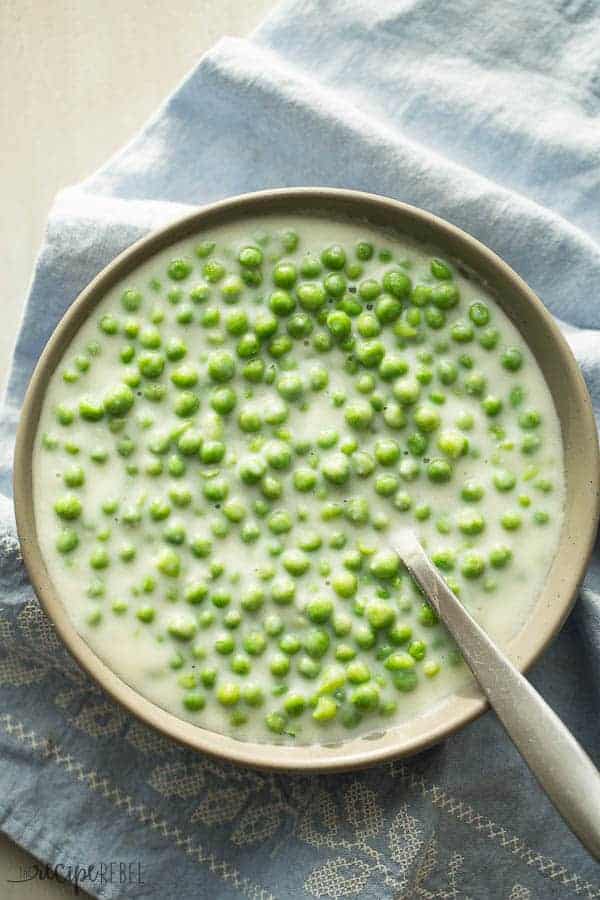 overhead image of bowl of creamed peas with a blue towel underneath