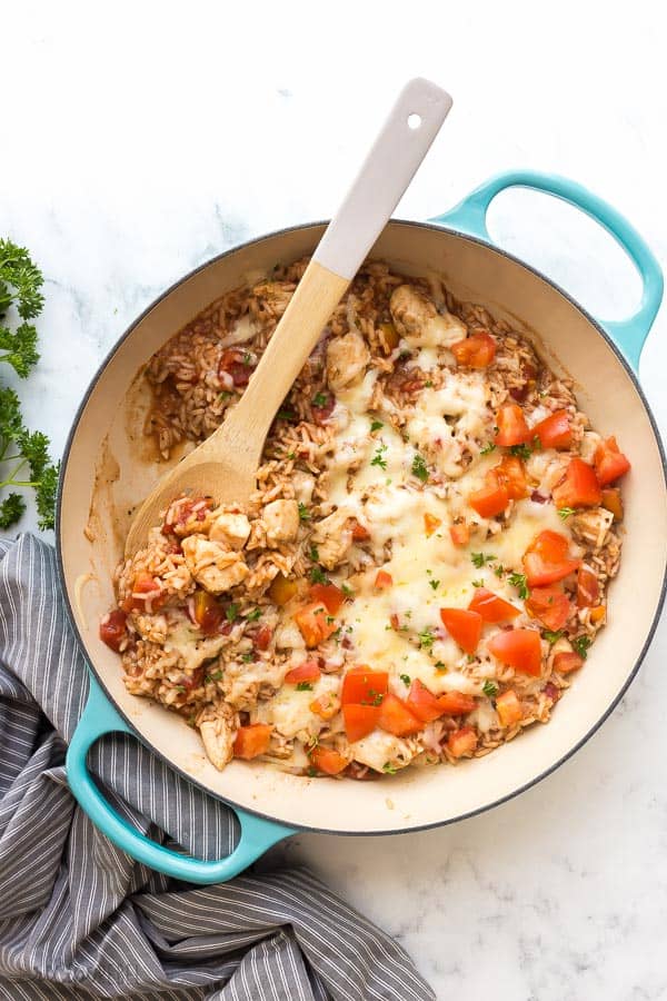 caprese chicken and rice overhead with wooden spoon scoop