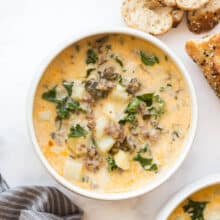 overhead image of one bowl of zuppa toscana with bread