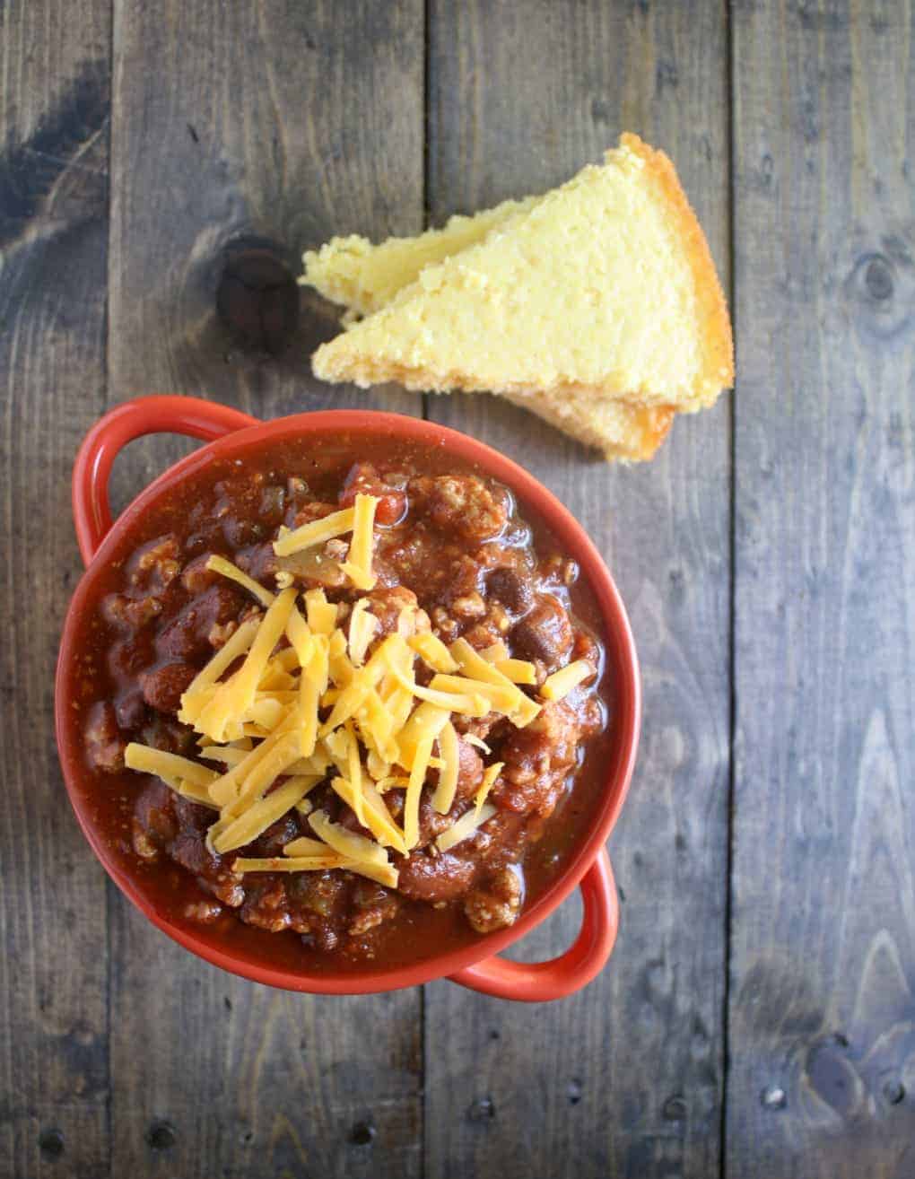 crockpot turkey chili overhead in red bowl on wooden background