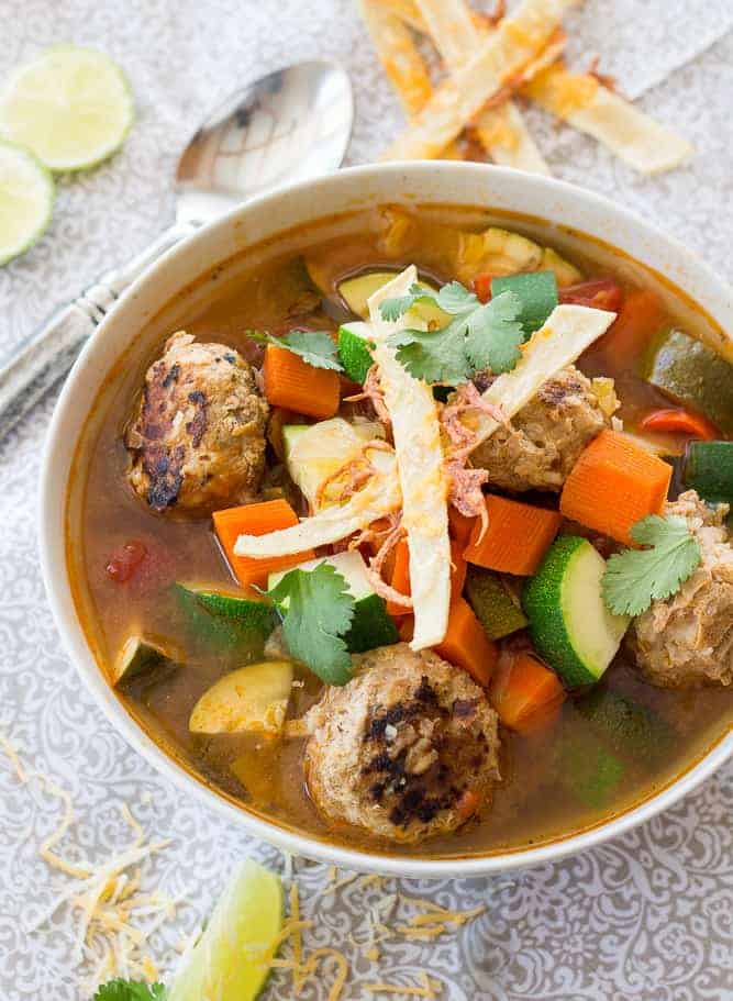 mexican meatball soup topped with tortilla strips and cilantro