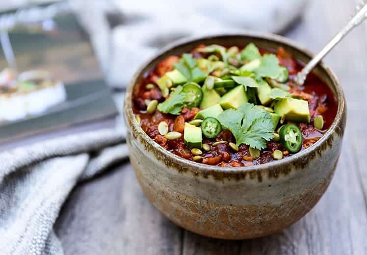 turkey chili in grey bowl with jalapenos cilantro and avocado on top