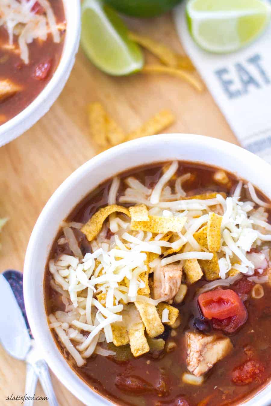 chicken tortilla soup overhead in white bowl with tortilla strips and cheese