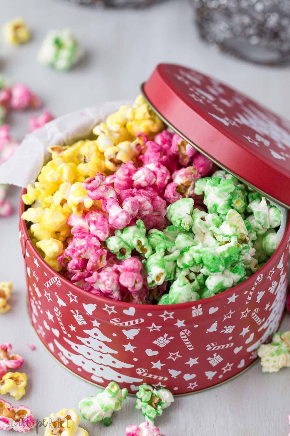pink yellow and green candy popcorn in red christmas tin