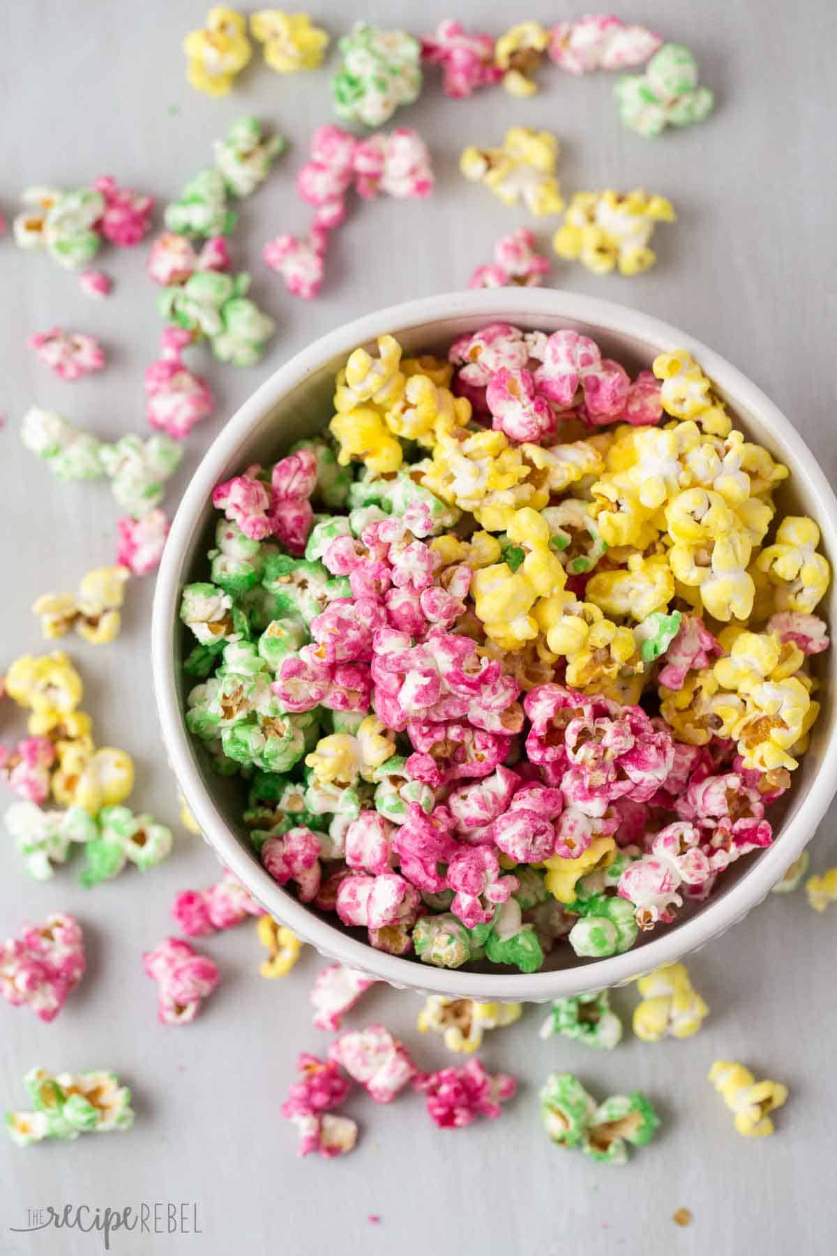 candy popcorn in pink green and yellow in white bowl on a grey background