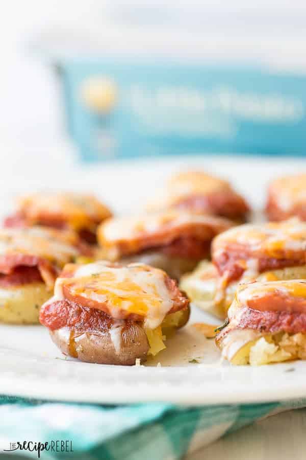 close up image of pizza smashed potatoes on white plate with blue napkin underneath