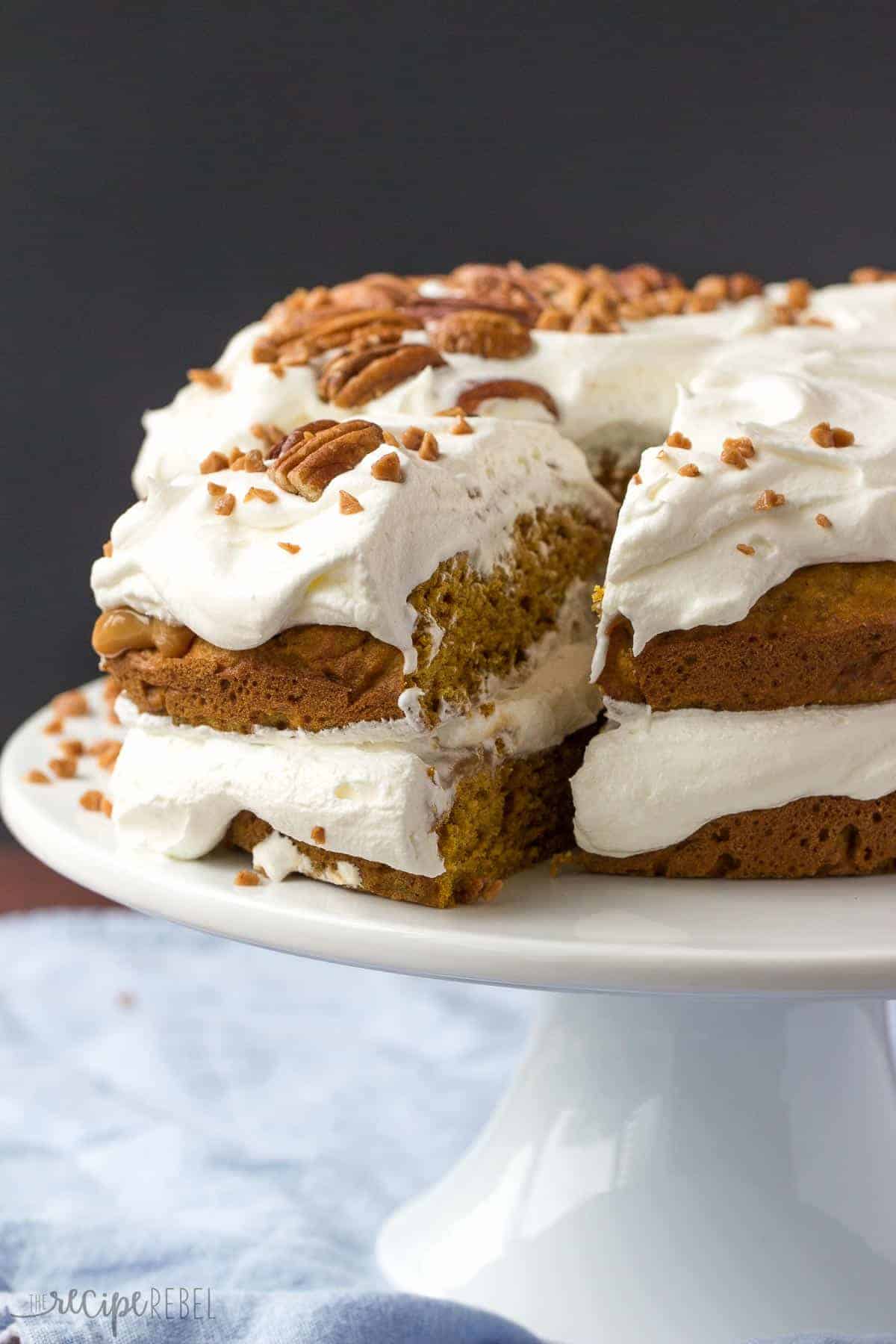 slice of pumpkin caramel cake being pulled out of whole on white cake plate