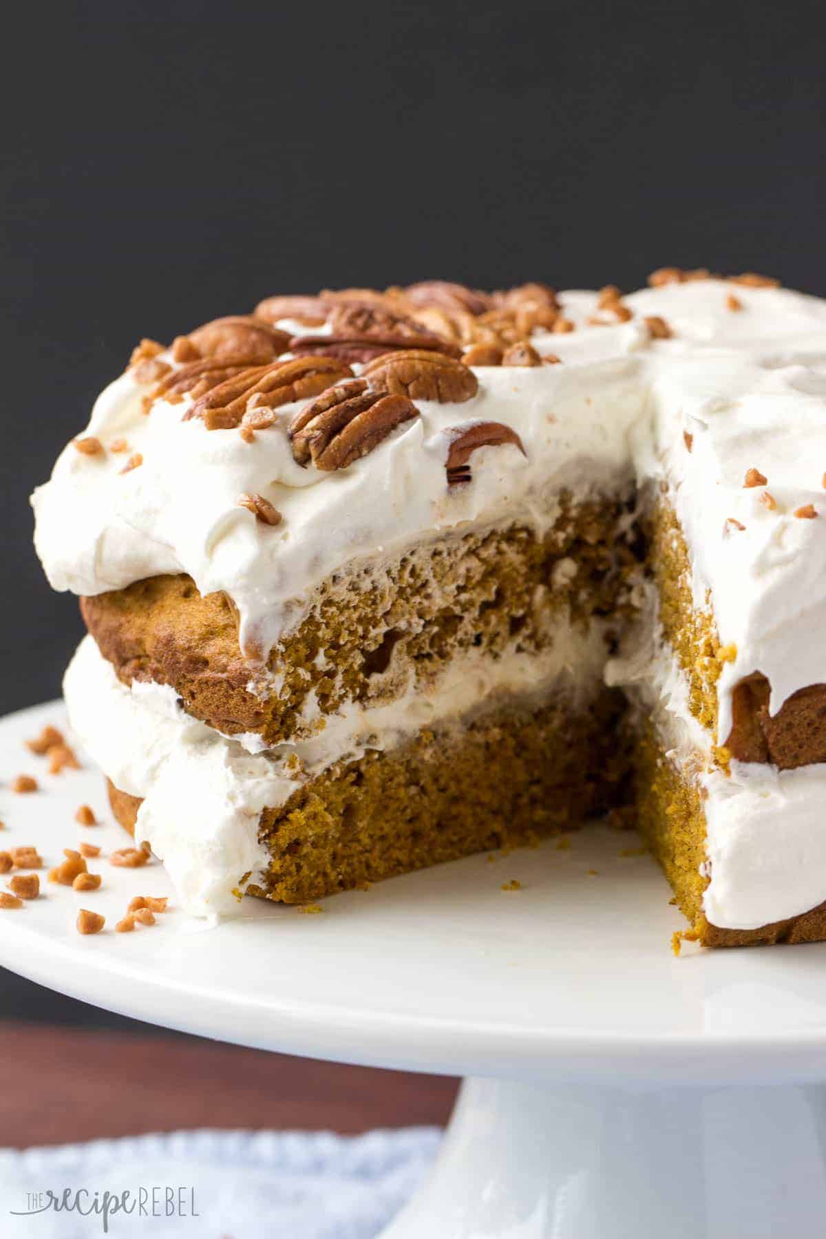 whole pumpkin caramel naked cake with slice removed on white cake plate