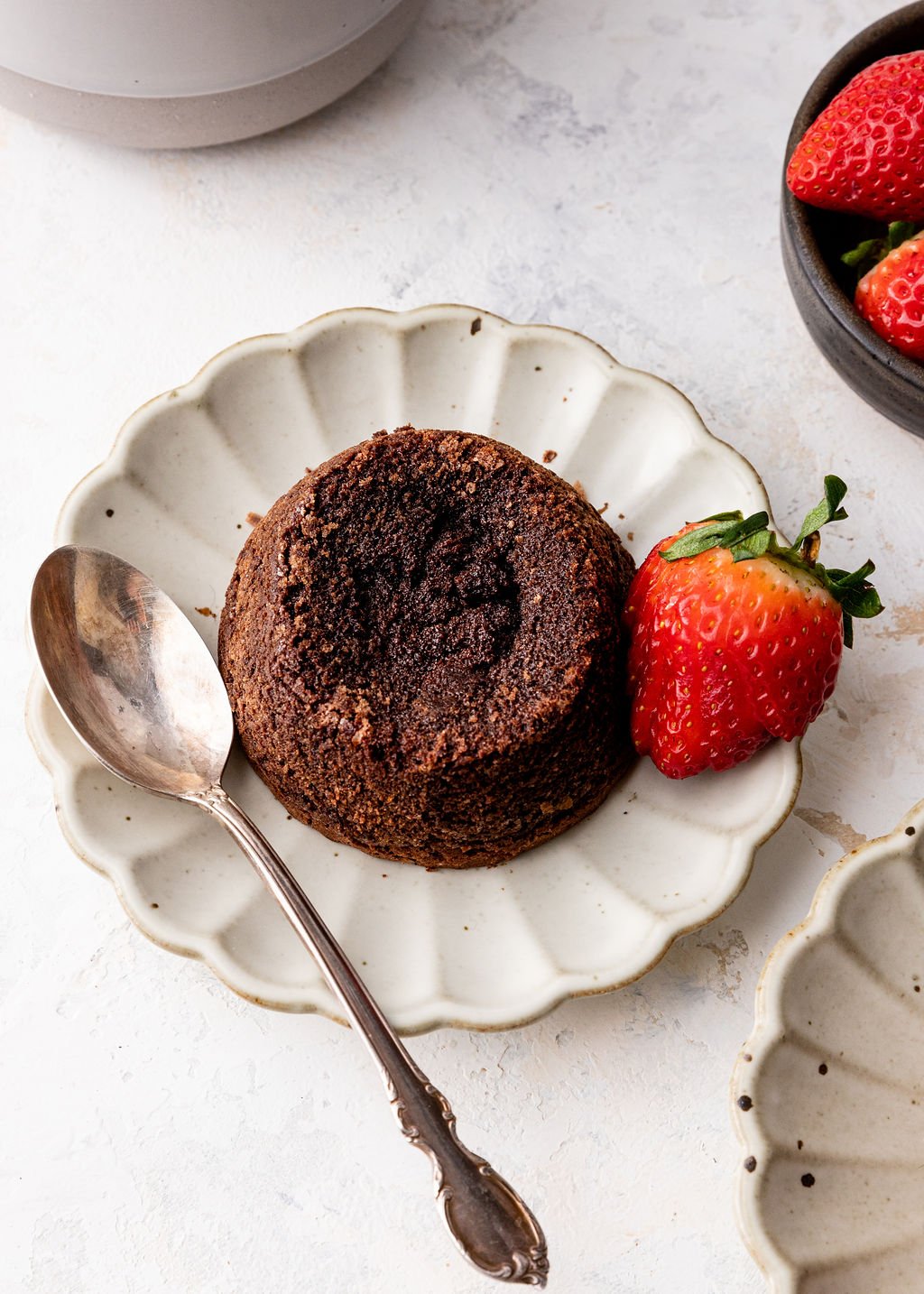 whole molten lava cake on plate with strawberry.