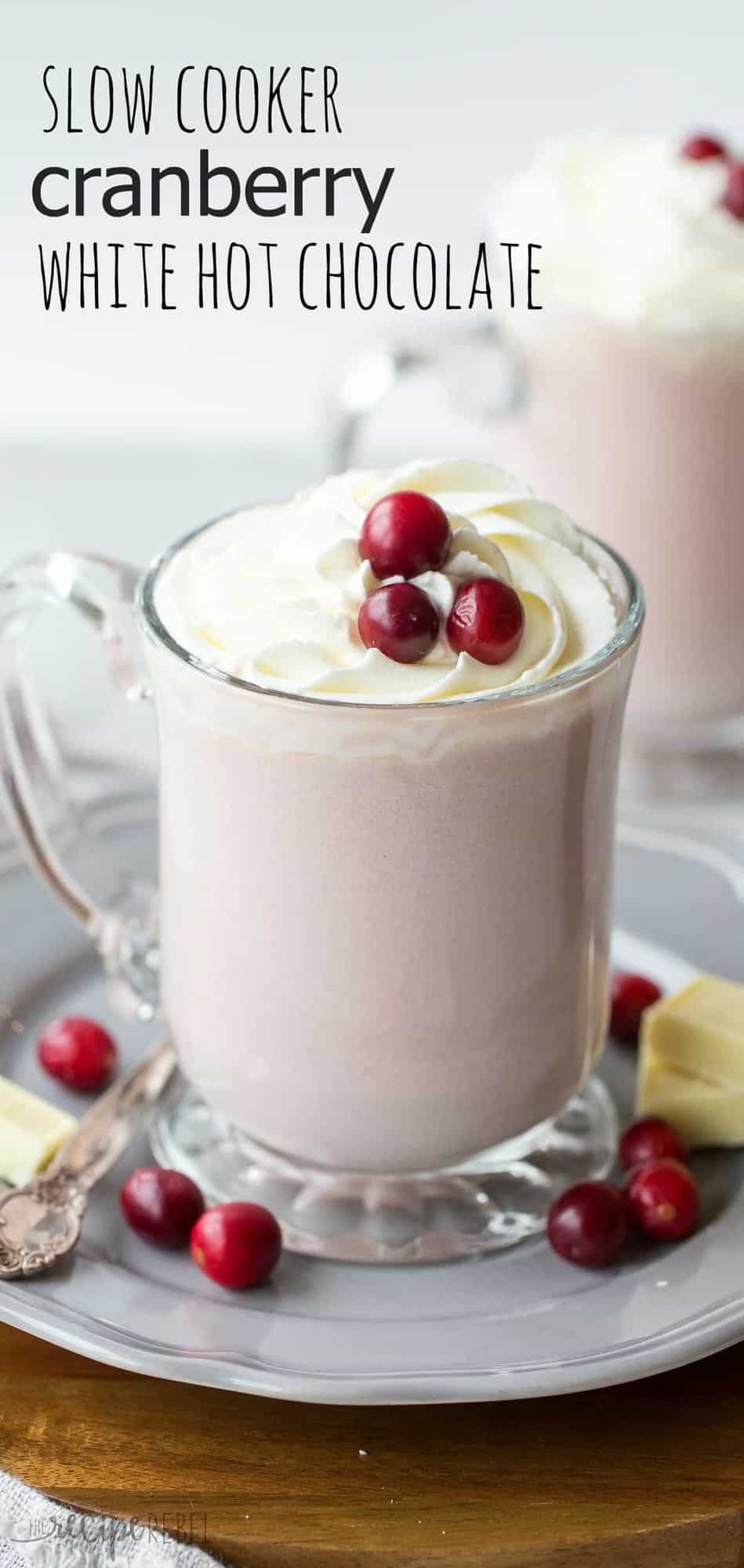 close up of glass mug with cranberry white hot chocolate topped with whipped cream