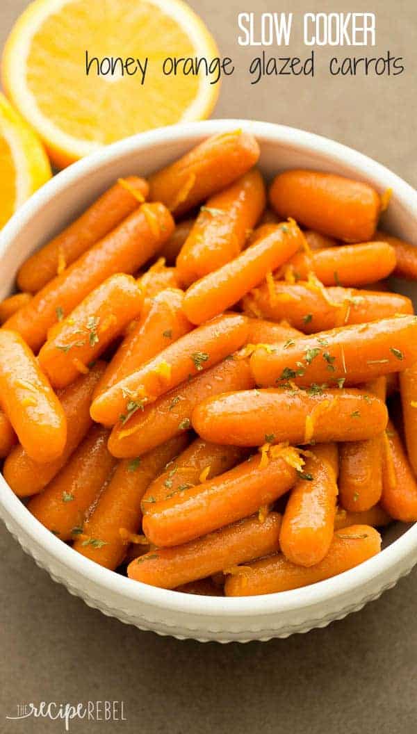 slow cooker honey orange glazed carrots in white bowl with orange zest and parsley on top