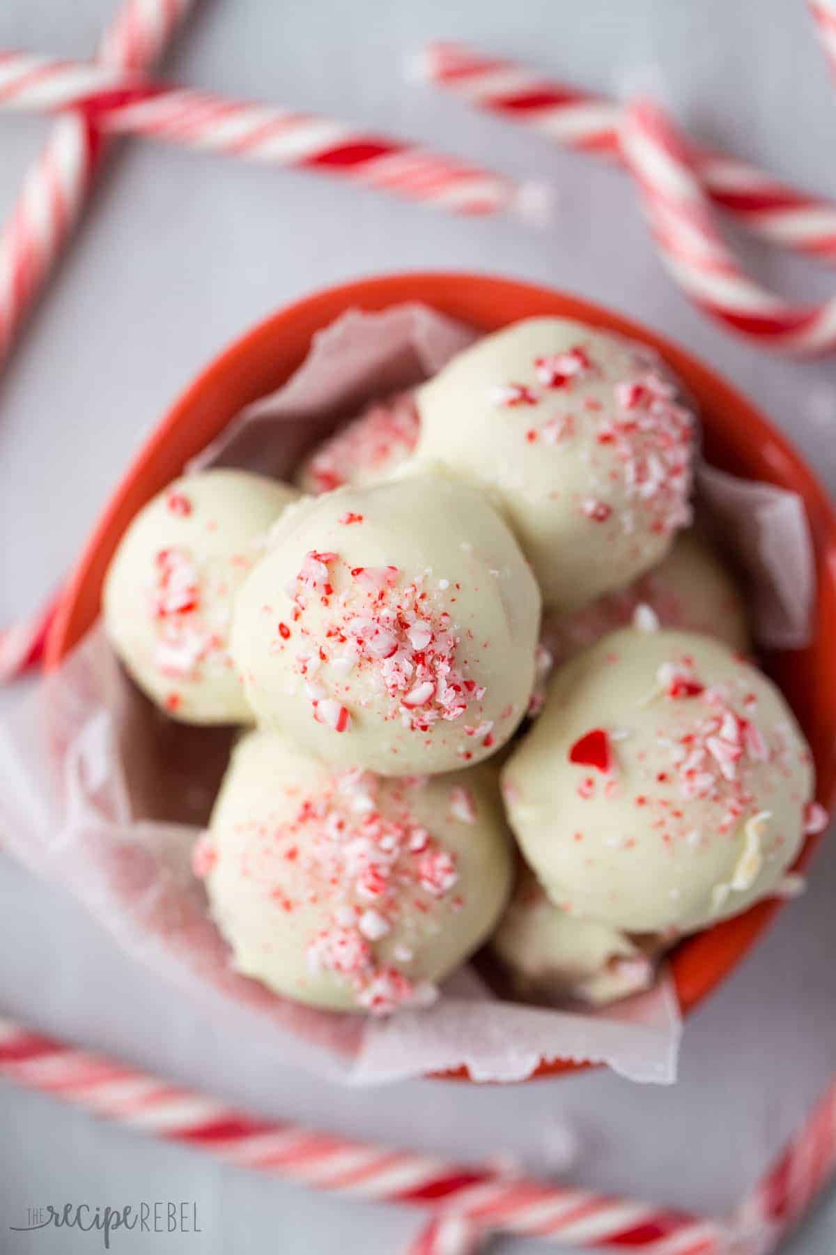 overhead image of white chocolate peppermint truffles in red bowl topped with crushed candy canes