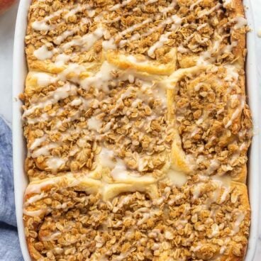 overhead image of pan of cinnamon rolls with streusel and glaze.