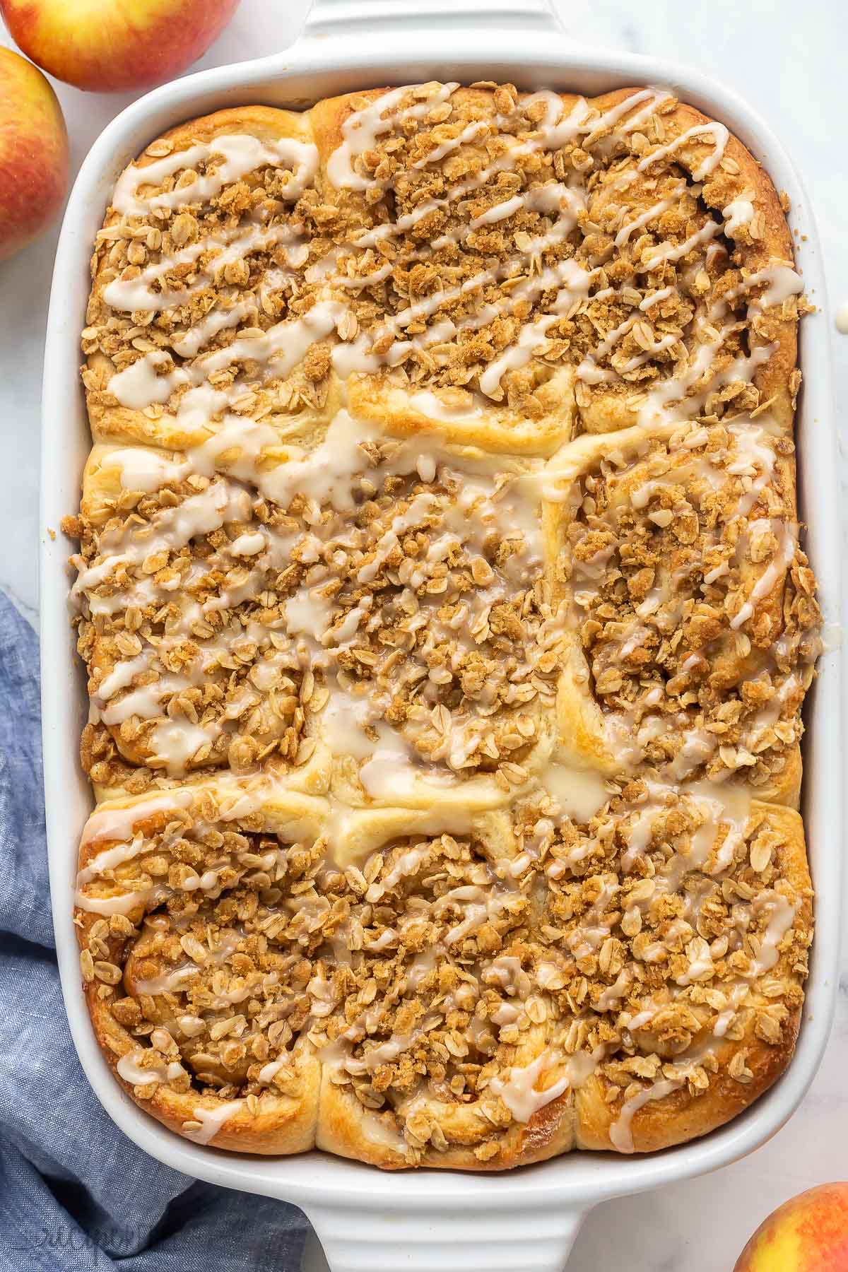 overhead image of pan of cinnamon rolls with streusel and glaze.