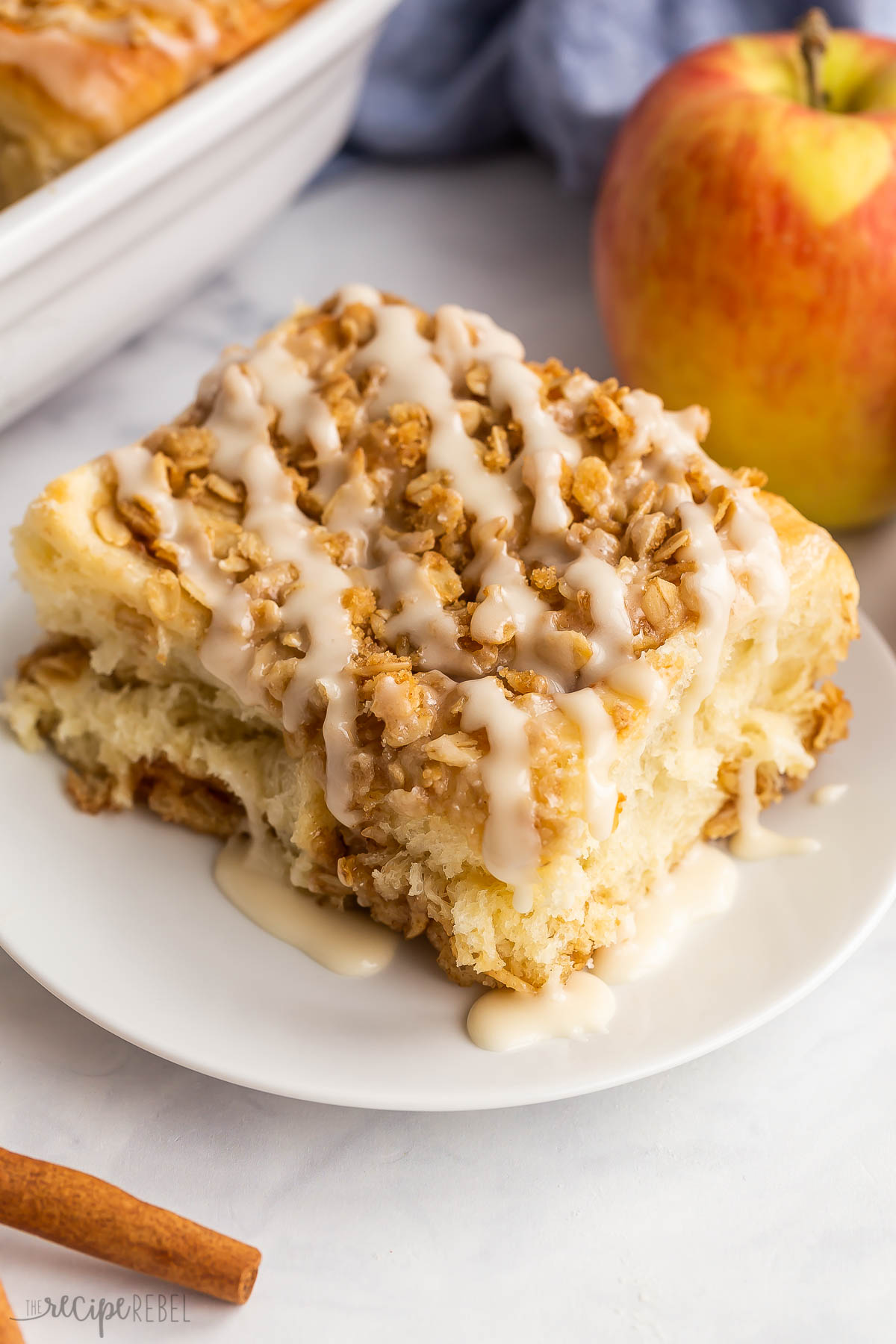 apple cinnamon bun on white plate with streusel.