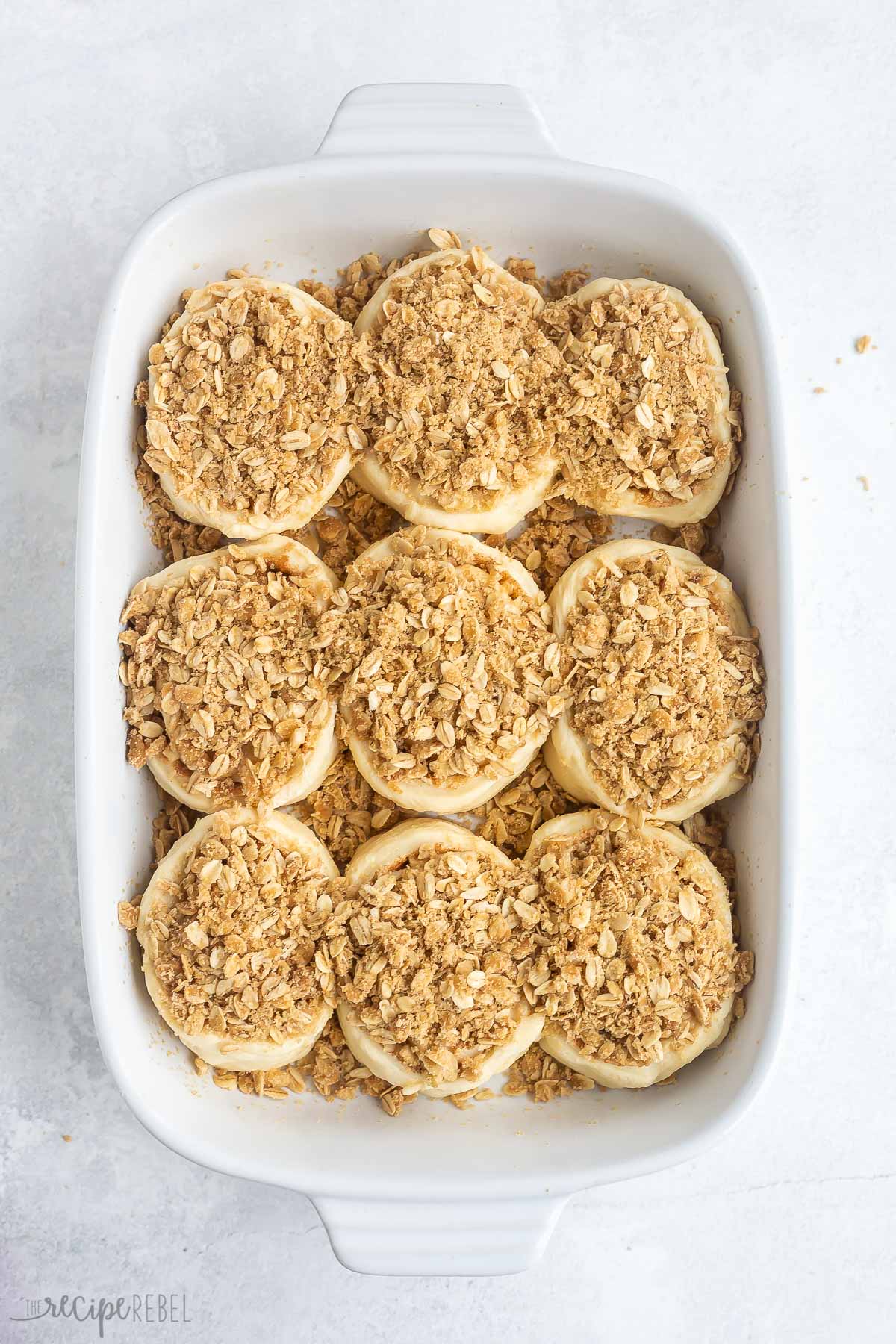 apple cinnamon rolls in pan after rising and topped with streusel.