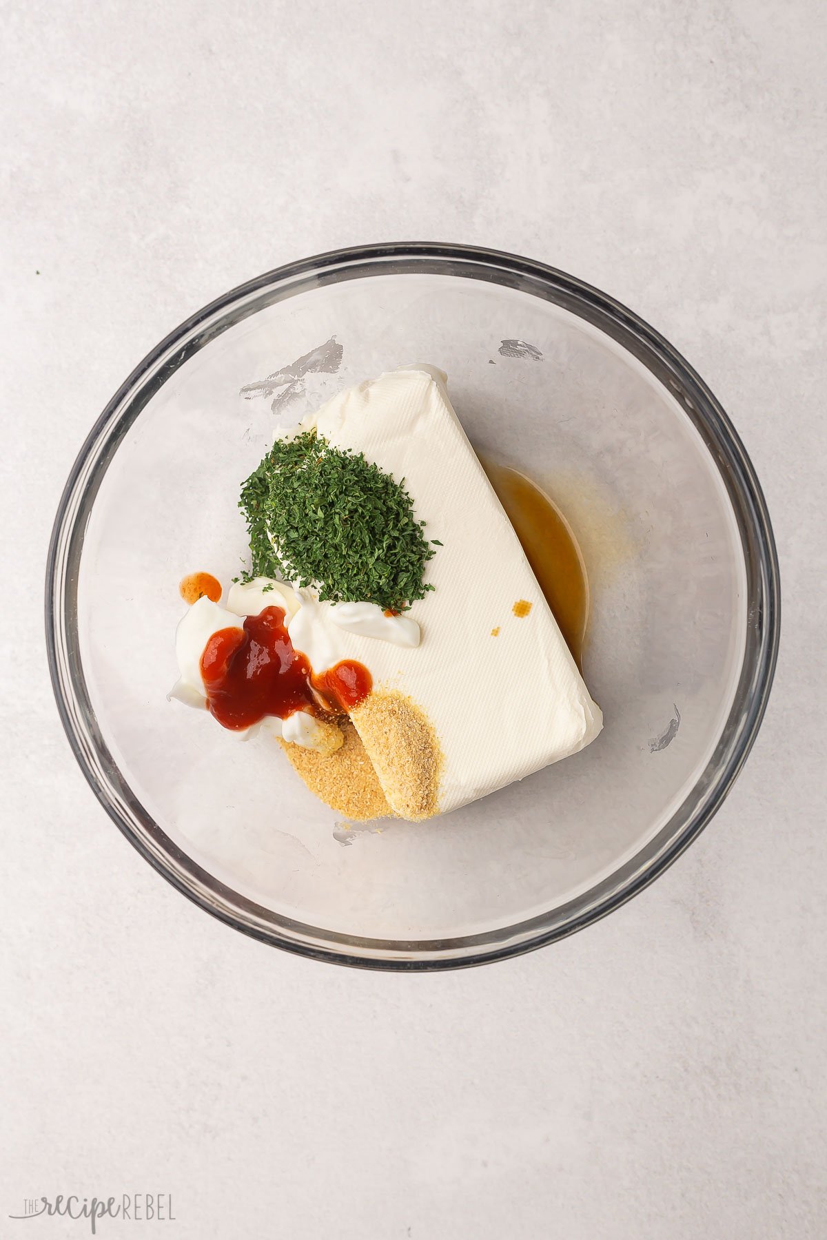 cream cheese with seasonings in a glass bowl.