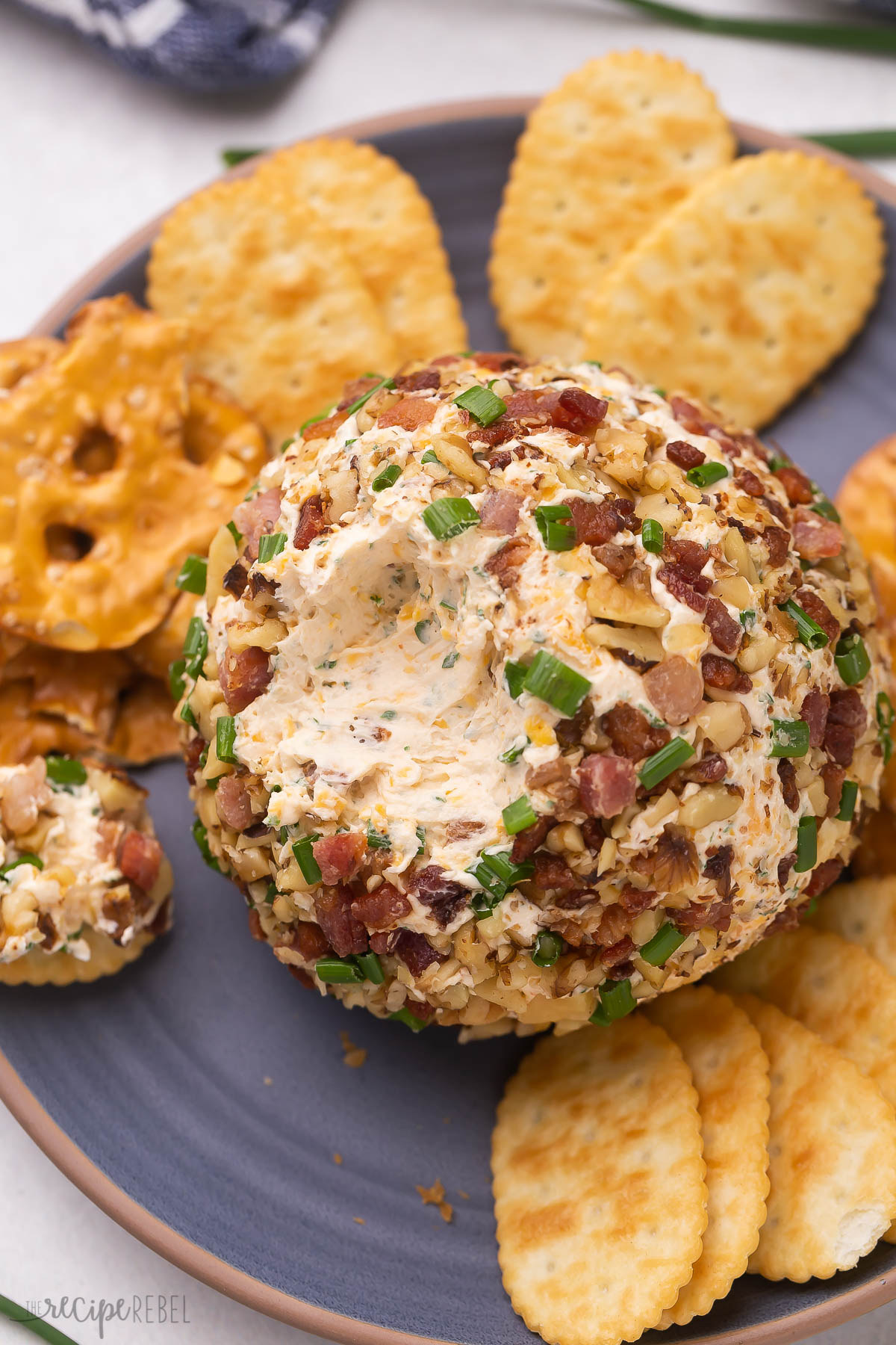 close up image of cheese ball with some scooped out on a cracker.