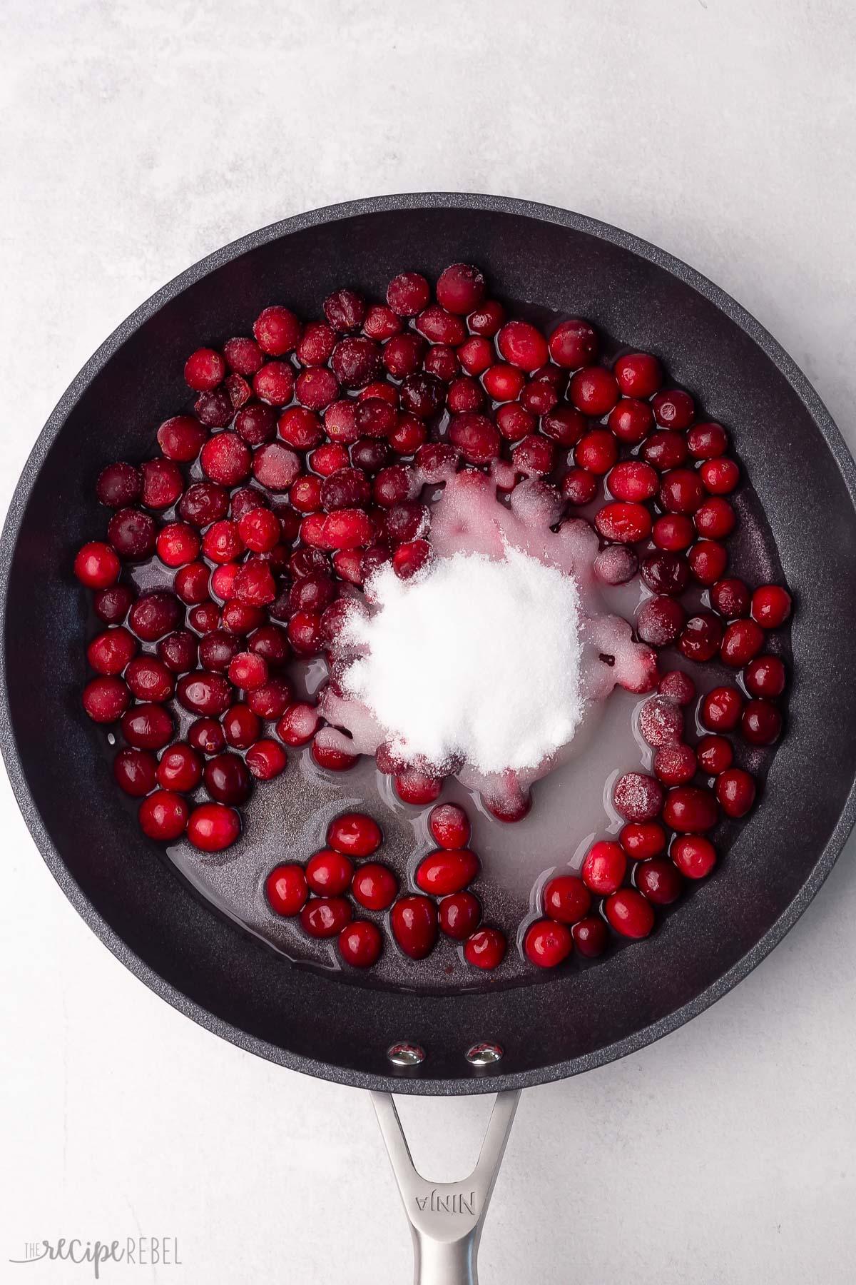 sugar water and cranberries in black skillet.