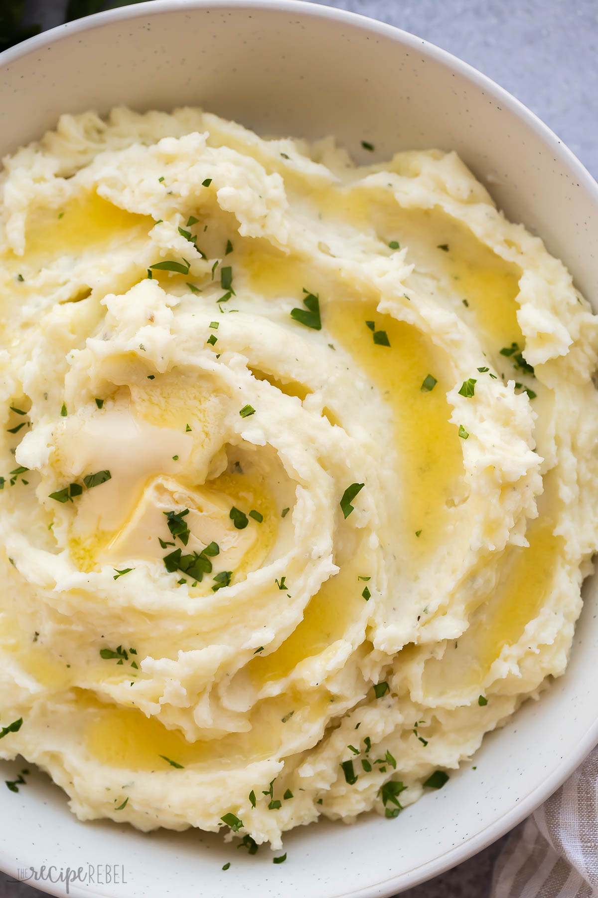 close up image of cream cheese mashed potatoes with melted butter.