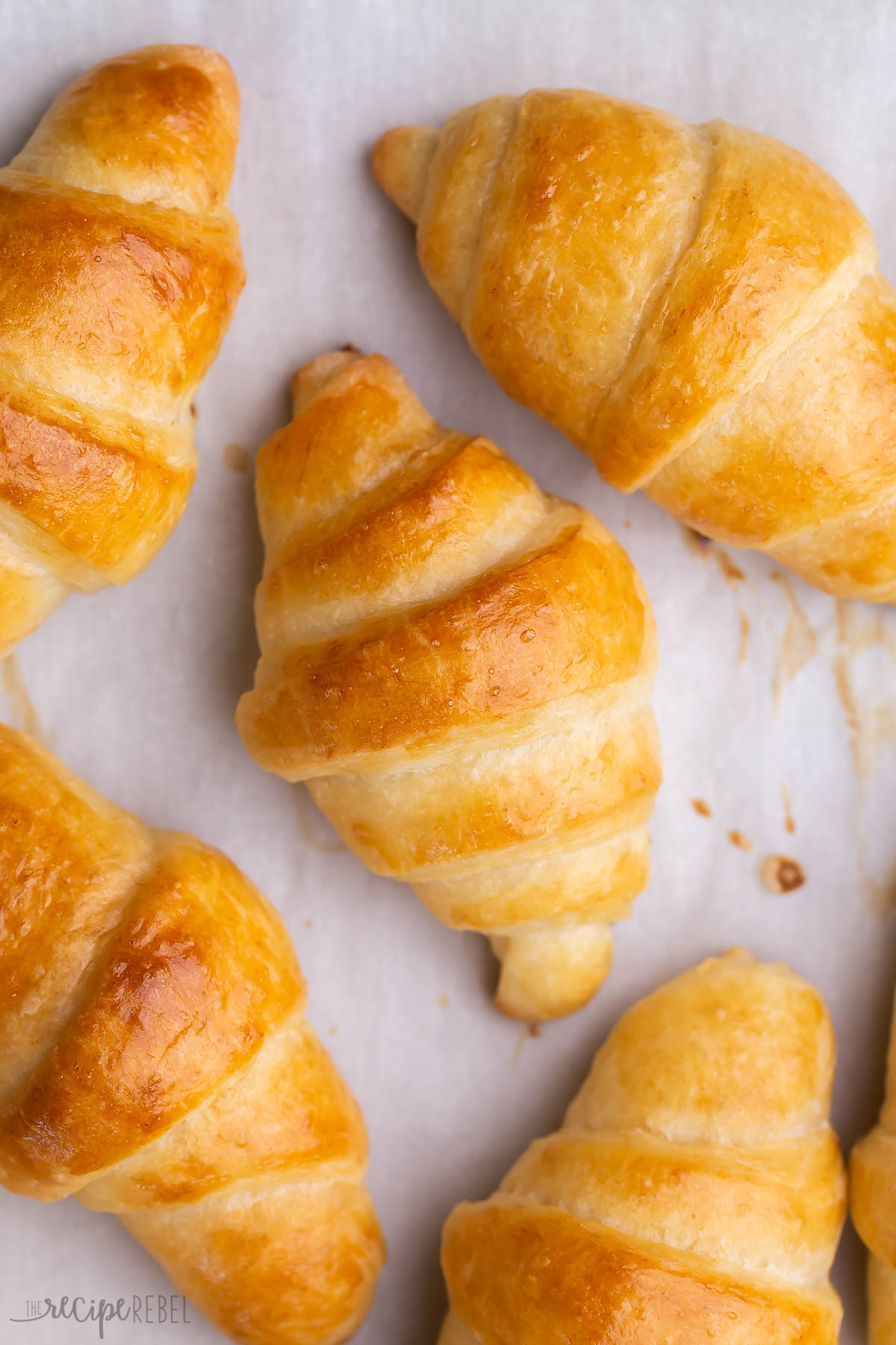 very close image of crescent rolls on baking sheet with parchment paper.