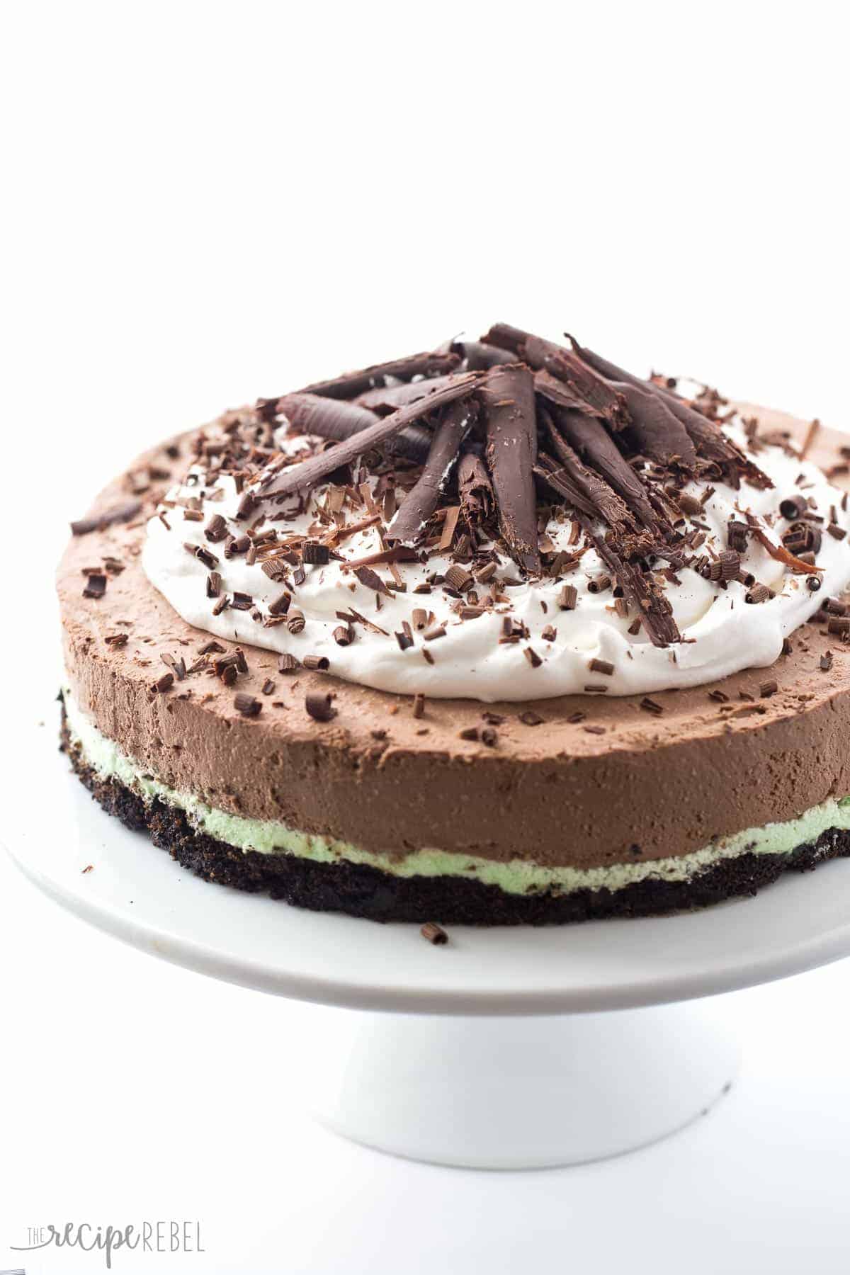 no bake mint chocolate cheesecake with green mint layer chocolate layer and topped with whipped cream