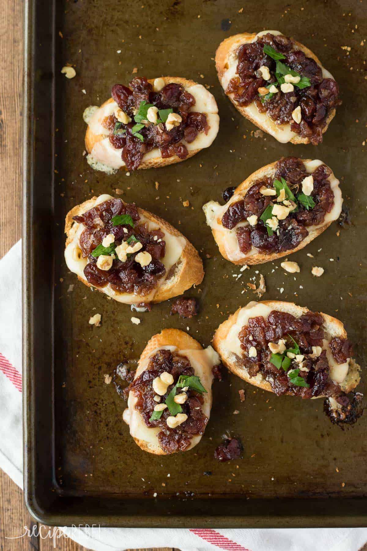 overhead image of six cranberry bacon jam crostini on sheet pan