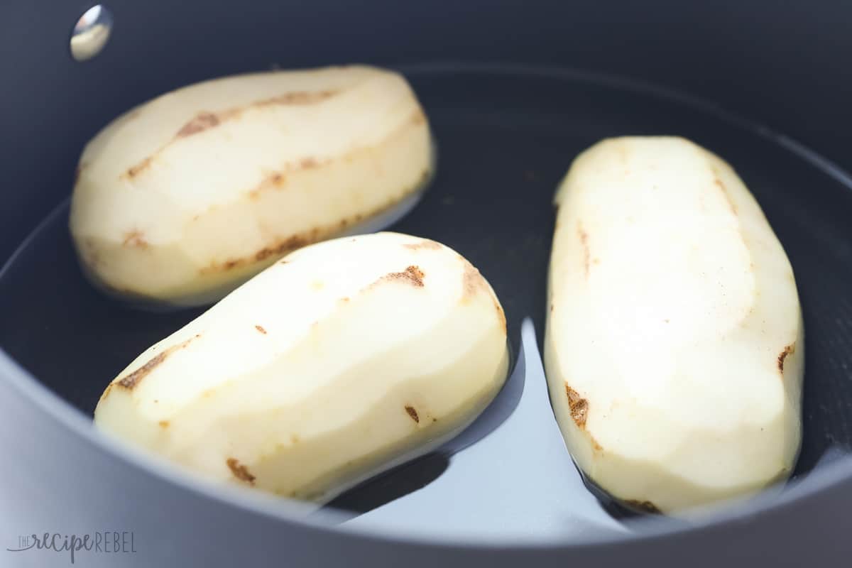 peeled whole potatoes in pot with water