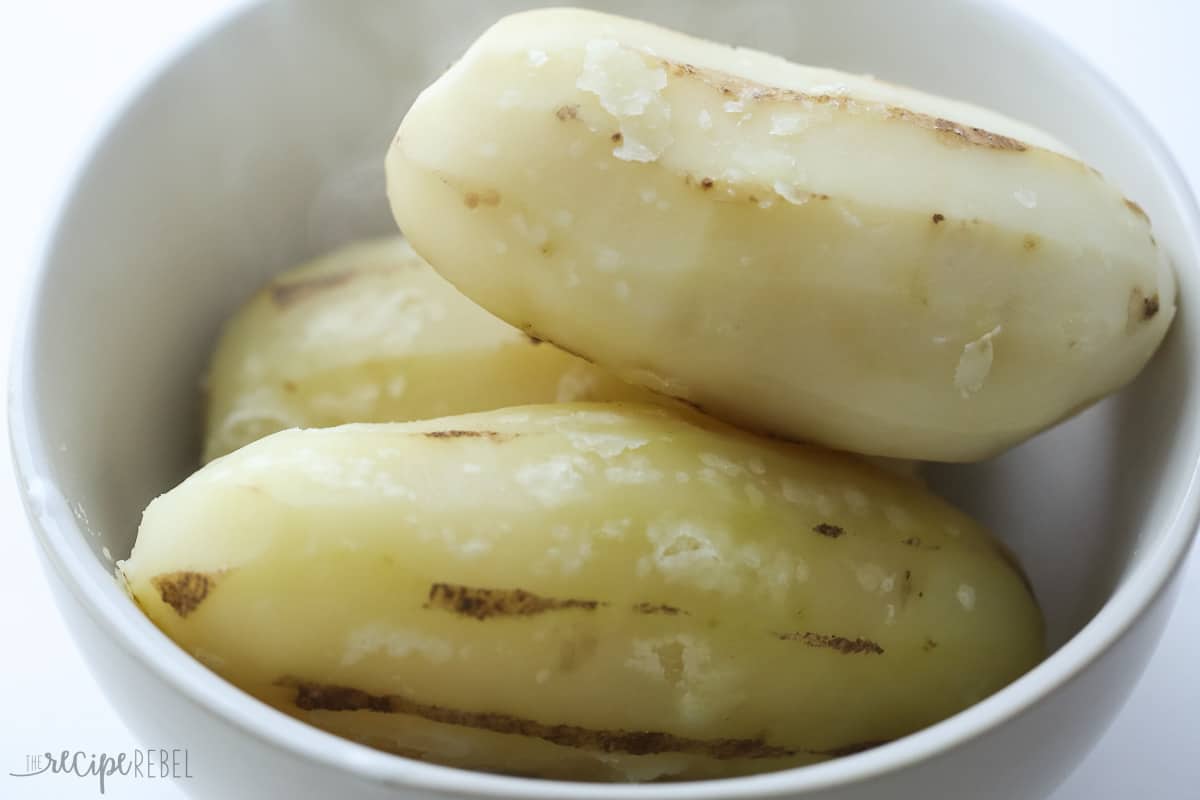 whole peeled cooked potatoes in bowl ready to shred