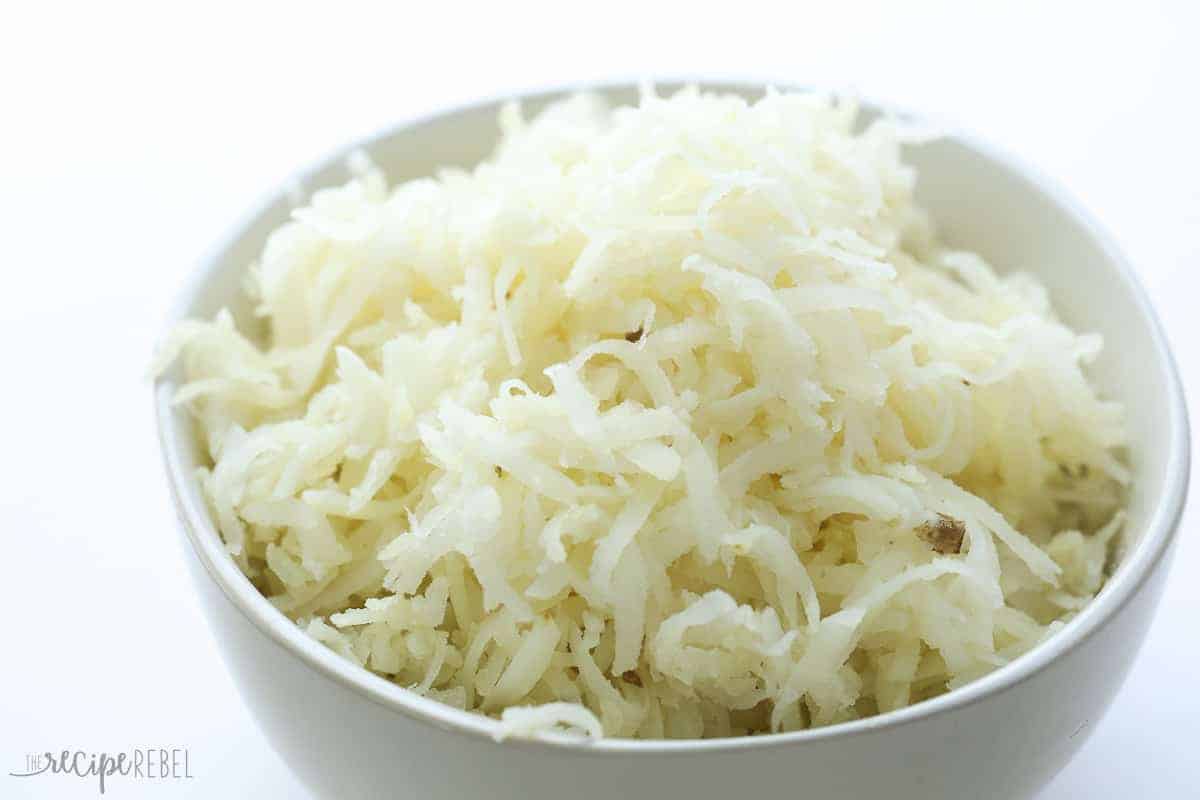 par cooked shredded potatoes in white bowl