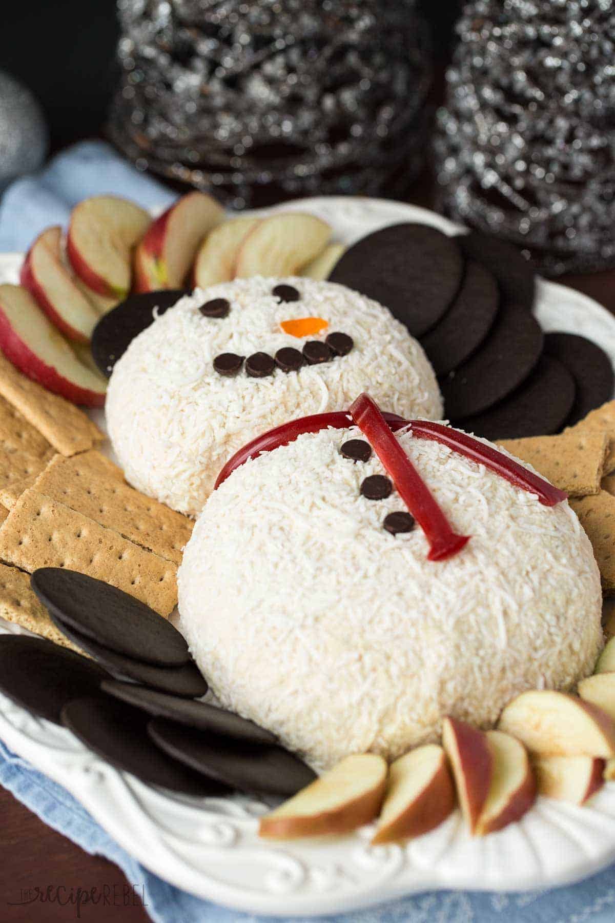 white chocolate toffee snowman cheese ball on platter with graham cracker and apple slices