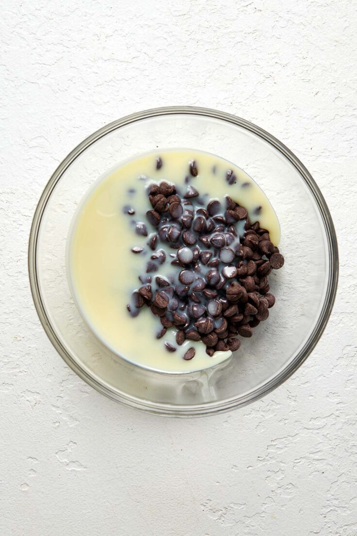 chocolate chips and sweetened condensed milk in a glass bowl.
