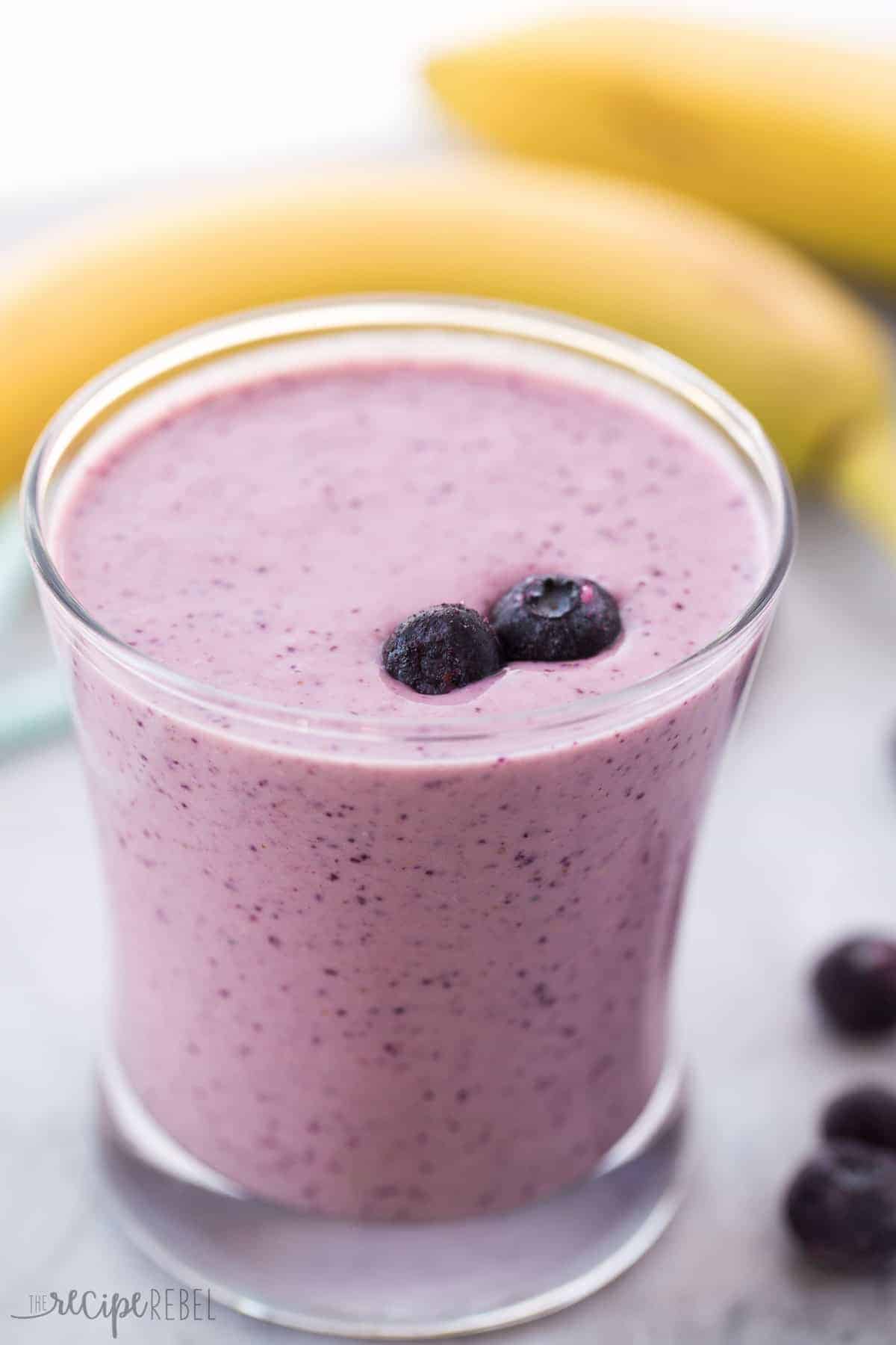 close up image of metabolism boosting smoothie with blueberries and bananas in the background
