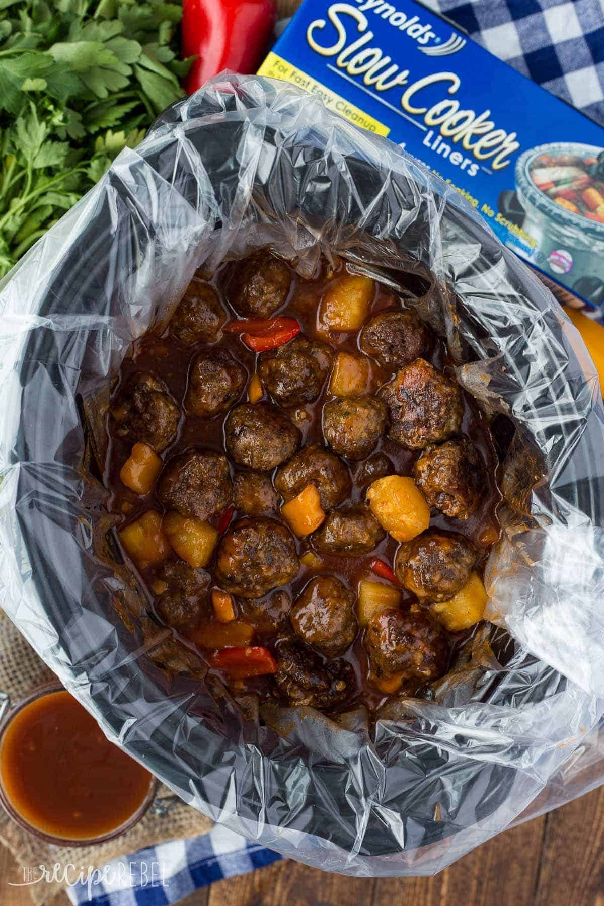 overhead image of large slow cooker with meatballs and sauce in a slow cooker liner