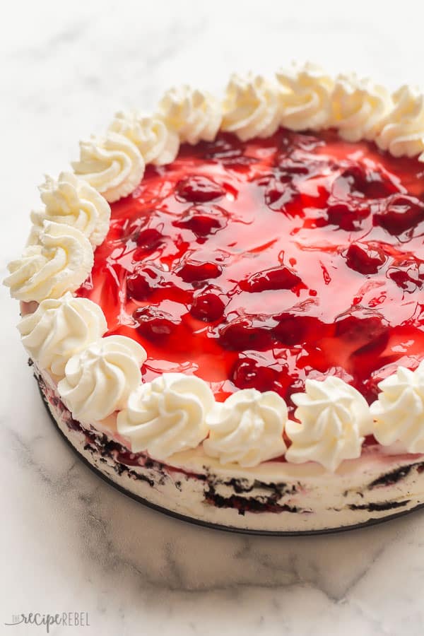 black forest icebox cake whole with whipped cream swirls and cherry pie filling