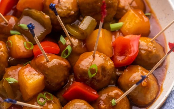 square image of slow cooker pineapple brown sugar meatballs with toothpicks.