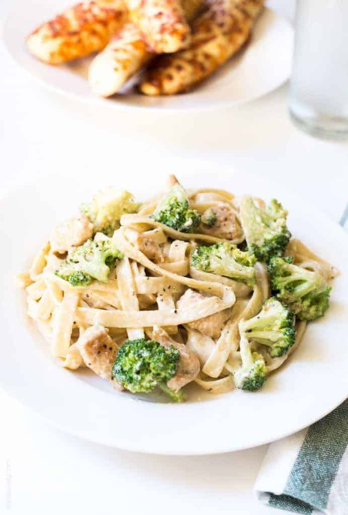 broccoli chicken alfredo with fettuccine on white plate